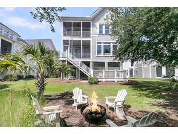 Relaxing backyard features a fire pit, Adirondack chairs, and a spacious lawn at 2072 Amenity Park Dr, Mount Pleasant, SC 29466