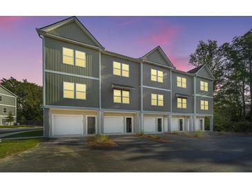 Modern townhome with attached garages, gray siding, and well-maintained landscaping at 208 Cache Ct, Charleston, SC 29414