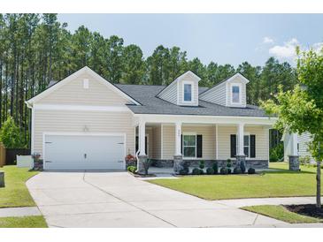 Charming home featuring a two-car garage, a covered porch, and a well-manicured lawn at 209 Country Gate Ln, Summerville, SC 29485