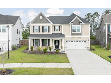 Charming two-story home with a manicured lawn, covered porch, and two-car garage at 283 Saxony Loop, Summerville, SC 29486