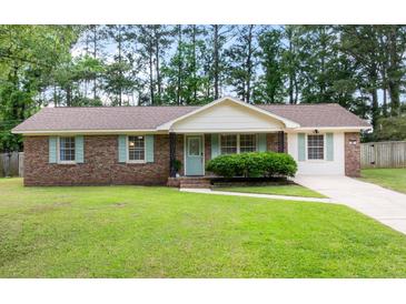 Charming brick home with well-maintained lawn, light blue shutters, and mature trees at 305 Forest Cir, Summerville, SC 29483