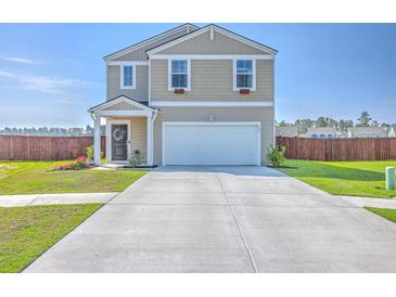 Two-story home featuring a two-car garage, well-maintained lawn, and charming curb appeal on a bright day at 307 Fox Gap Rd, Summerville, SC 29486
