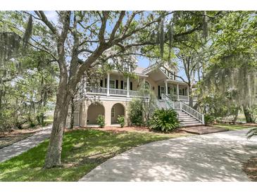 Stunning two-story home with mature trees and a wrap-around porch and elegant stairway entry at 4702 Blockhouse Ln, Hollywood, SC 29449