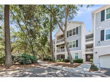 Charming gray multi-story condo building with balconies and lush landscaping in a desirable neighborhood at 60 Fenwick Hall Aly # 415, Johns Island, SC 29455