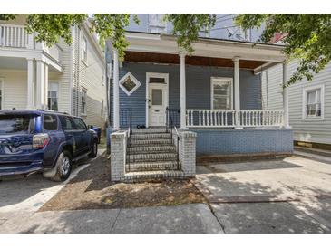 Charming two-story home with blue siding, a cozy front porch, and inviting brick steps at 634 Rutledge Ave, Charleston, SC 29403