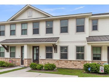 Charming townhome with white siding, stone accents, and a covered entryway, creating curb appeal at 7812 Park Gate Dr, North Charleston, SC 29418
