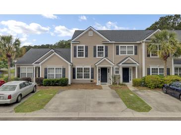 Charming townhome featuring neutral siding, black shutters, well-maintained landscaping, and a private driveway in a desirable community at 1005 Washitonia Way # B, Charleston, SC 29492