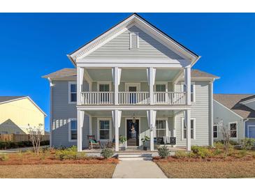 Charming two-story home featuring a double front porch with rocking chairs and swing at 128 Sandy Bend Ln, Summerville, SC 29486