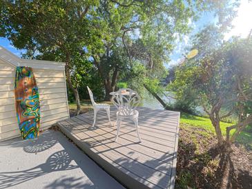 View of a deck with white chairs overlooking the water surrounded by greenery at 15 Town Park Ln # A, Charleston, SC 29412