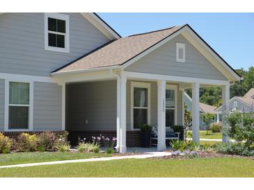 Charming covered front porch featuring white columns and landscaped front yard at 2020 Parish House Cir, Johns Island, SC 29455