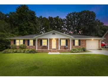 Charming single story brick home featuring a manicured front lawn and covered porch with swing at 2045 Vestry Dr, Charleston, SC 29414