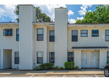 Inviting townhouse with light yellow siding, complemented by lush green bushes and ample parking at 235 Pine Shadow Dr, Goose Creek, SC 29445