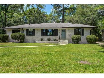 Charming single-story home featuring a well-manicured lawn and a classic brick facade at 408 N Palmetto St, Summerville, SC 29483