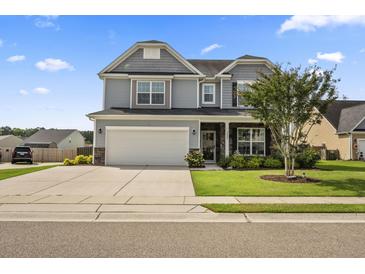 Charming two-story home with a well-manicured lawn, gray siding, and a two-car garage at 9009 Chato Ct, Summerville, SC 29483