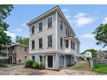 Charming three-story home featuring light-blue painted siding with a quaint front yard and well-kept landscaping at 6 Kirkland Ln, Charleston, SC 29401