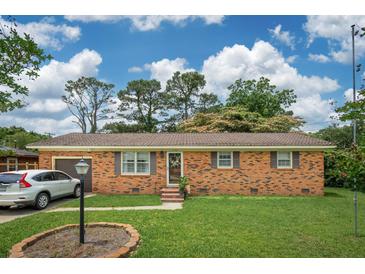 Charming single-story brick home with a well-manicured lawn, attached garage, and inviting curb appeal at 1160 Landsdowne Dr, Charleston, SC 29412