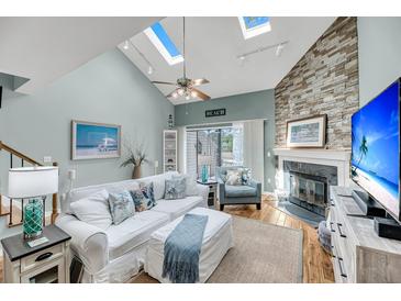 Bright living room boasts a vaulted ceiling, fireplace, skylights and comfortable seating for relaxation at 166 River Breeze Dr, Charleston, SC 29407