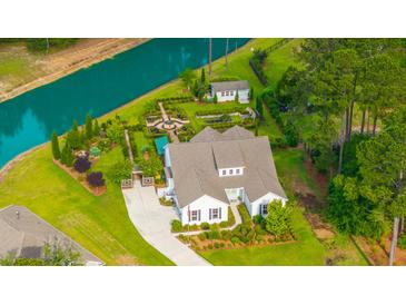 Stunning aerial view of the home with lush landscaping, a lovely garden, and a serene waterfront at 225 Camber Rd, Huger, SC 29450