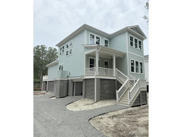 Charming, elevated two-story home featuring light blue siding and white trim accents at 2790 Burden Creek Rd, Johns Island, SC 29455