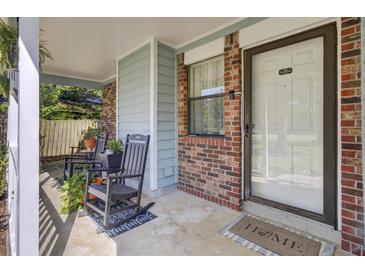 Charming front porch featuring rocking chairs and brick accents, inviting relaxation and curb appeal at 406 Carolina Cir, Ladson, SC 29456