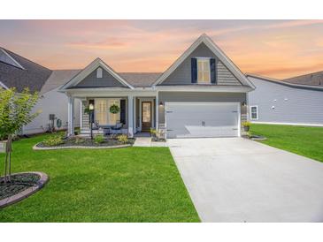 Charming home with a manicured lawn, covered porch, and a two-car garage at 413 Eagleview Dr, Moncks Corner, SC 29461