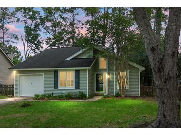 Charming single-Gathering home with a well-manicured lawn and attached garage nestled among mature trees at 7886 Racquet Rd, North Charleston, SC 29418