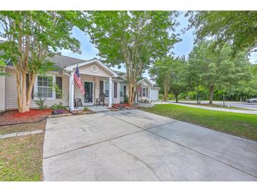 Charming single-story home featuring a spacious driveway, manicured lawn, and inviting front porch at 8028 Vermont Rd, North Charleston, SC 29418