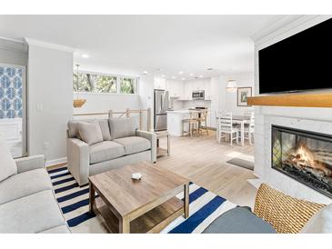 Bright living space with fireplace, modern furnishings, and open floor plan to the kitchen and dining area at 1355 Dunlin Ct # Share D, Kiawah Island, SC 29455