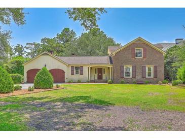 Charming brick home with a lush front lawn, two-car garage, and shuttered windows at 17 Johnson Rd, Charleston, SC 29407
