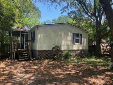 Charming single-story home with mature trees, complemented by a cozy porch and a well-kept yard at 2041 Covey Ln, Charleston, SC 29412