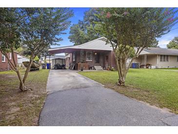Charming brick home with covered parking, a well-kept lawn, and mature trees at 2703 Phyllis St, North Charleston, SC 29405