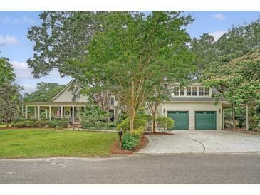 Charming home with a covered porch, mature trees, and a two-car garage with green doors at 312 Hobcaw Dr, Mount Pleasant, SC 29464