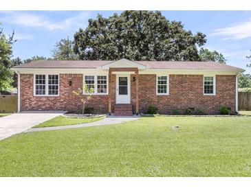 Charming brick home featuring a manicured lawn, inviting walkway, and classic architectural details at 334 Water Oak Dr, Goose Creek, SC 29445