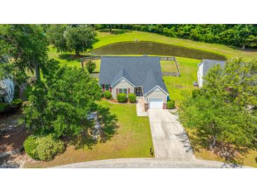 Charming home with well-manicured lawn and a pond view, complete with an attached single-car garage and mature trees at 5128 Thornton Dr, Summerville, SC 29485