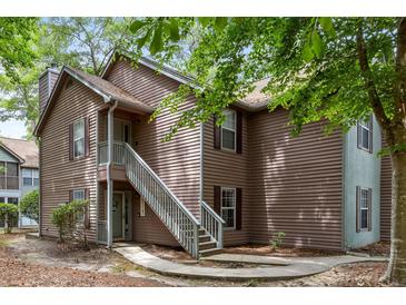 Two-story condo featuring wood siding and a stairway leading to the upper level entrance at 7935 Parklane Ct # A, North Charleston, SC 29418
