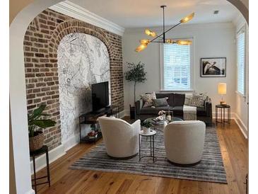 Bright living room features exposed brick, hardwood floors, and plenty of natural light at 84 Bull St # F, Charleston, SC 29401