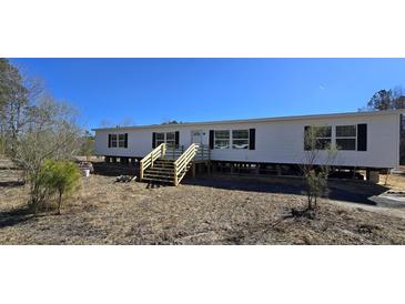 New manufactured home featuring black shutters and a small front porch with wooden steps at 934 Tiger Loop, Saint Stephen, SC 29479