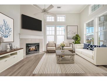 Bright living room with a fireplace, lots of natural light, and a cozy atmosphere at 130 River Landing Dr # 2310, Daniel Island, SC 29492