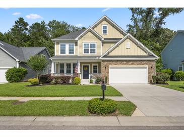 Charming two-story home featuring a manicured lawn, stone accents, and a cozy front porch with a white railing at 132 Daniels Ridge Dr, Summerville, SC 29485