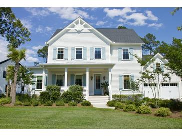 Charming two-story home featuring light blue shutters, a welcoming front porch, and beautifully landscaped yard at 1723 Bolden Dr, Mount Pleasant, SC 29466