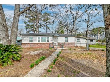 Charming single-story home with brick foundation, fenced yard, and walkway to the front door at 20 Stratton Dr, Charleston, SC 29420