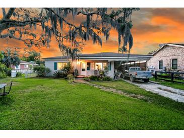 Charming single-story home with beautiful landscaping and a spacious front yard at sunset at 200 Wappoo Rd, Charleston, SC 29407