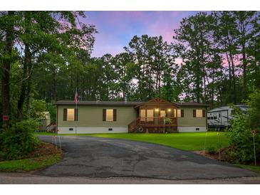 Charming single-story home with a front porch, a driveway, and surrounded by lush greenery and trees at 222 Sinclair Rd, Summerville, SC 29483