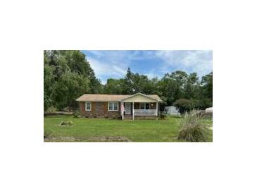 Charming single-story home with a brick facade, a covered porch, and a well-maintained front yard under a partly cloudy sky at 277 Carolina Cir, Walterboro, SC 29488