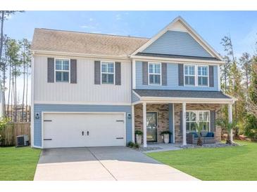 Charming two-story home with blue and white siding, attached garage, and well-manicured lawn at 301 Dunlin Dr, Summerville, SC 29486