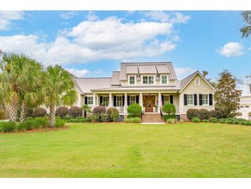 Expansive home featuring a large lawn, well-manicured landscaping, and inviting front porch at 4215 Ten Shillings Way, Ravenel, SC 29470