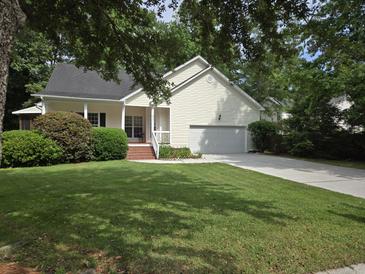 Charming home featuring a well-manicured lawn and a welcoming front porch, offering great curb appeal at 5347 Sundial Ct, North Charleston, SC 29418