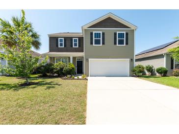 Charming two-story home featuring a spacious driveway and manicured lawn at 9711 Fanning Basket Ln, Ladson, SC 29456
