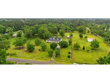 Expansive aerial view of a home with a long driveway, lush greenery, and outbuildings at 117 Ponderosa Rd, Summerville, SC 29483