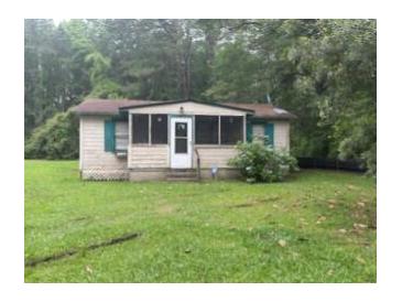 Modest single-story home with a screened-in porch and a white front door surrounded by green foliage at 137 Droze Rd, Summerville, SC 29483